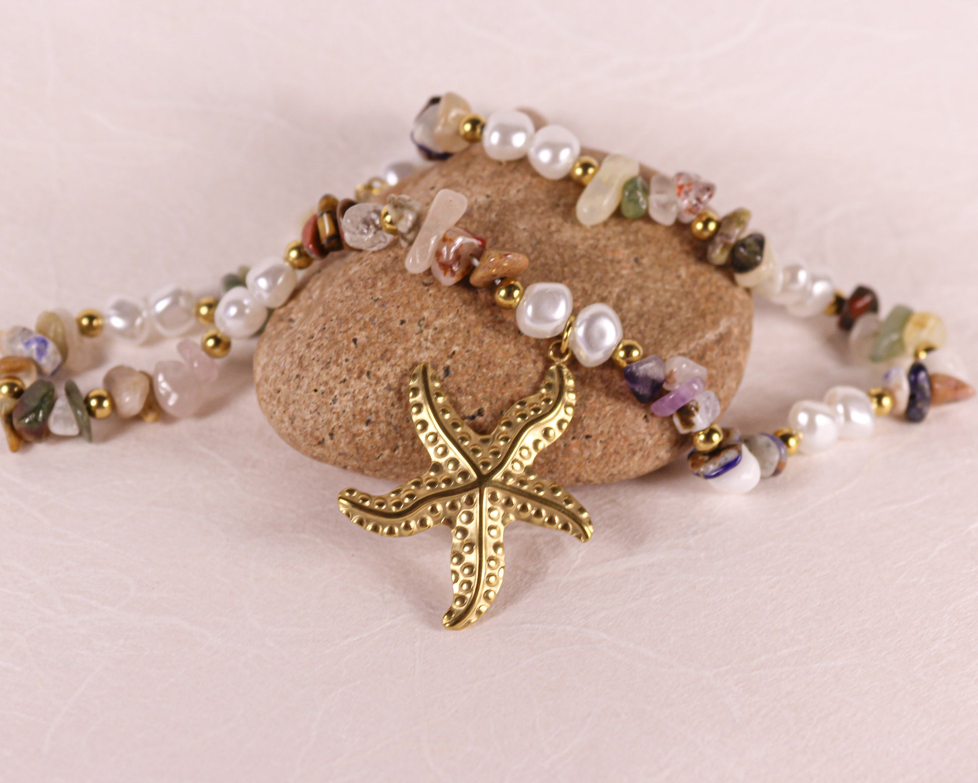 Necklace with starfish charm and multicolored beads on a stone surface
