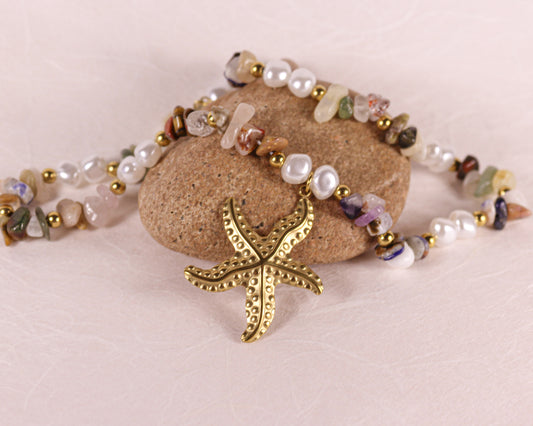 Necklace with starfish charm and multicolored beads on a stone surface