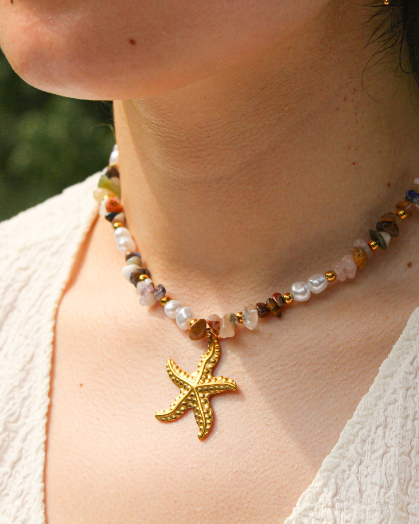Necklace with a starfish pendant worn by a person