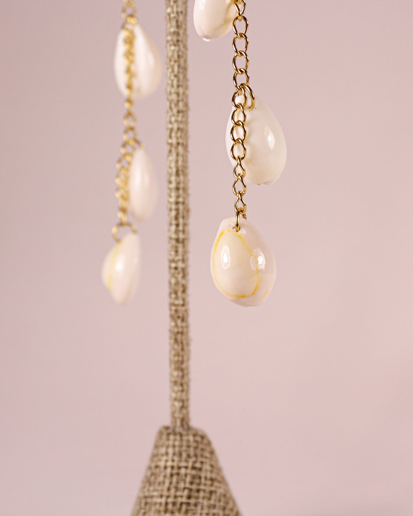 Earrings with teardrop-shaped pearls on a pink background